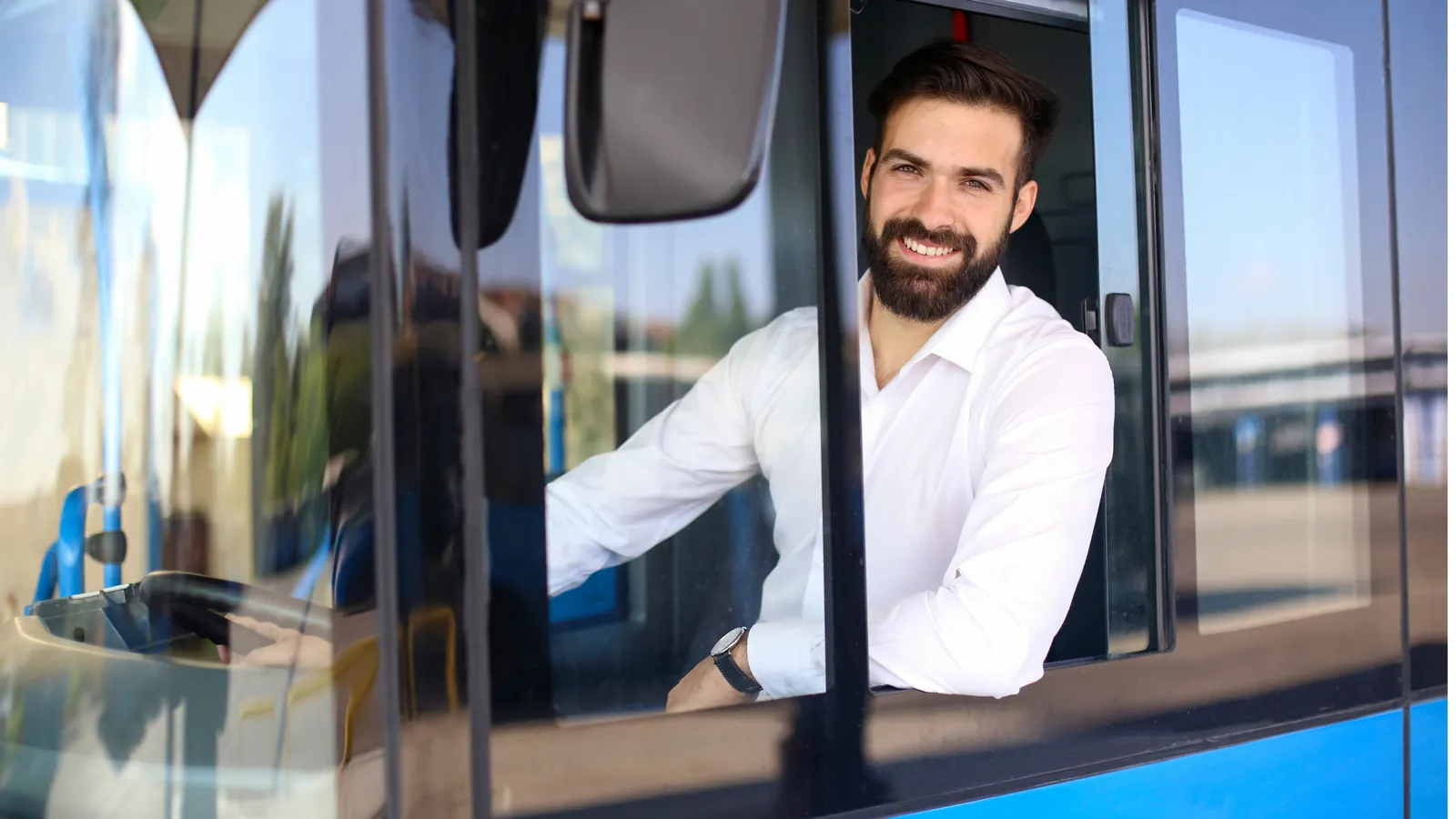 Smiling bus driver leaning out of the driver's window